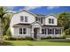Charming two-story home with stone accents, white siding, blue shutters, and a beautifully landscaped front yard at 1058 Cloud Ridge Ct, Mount Dora, FL 32757