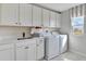 Bright laundry room with white cabinetry and a window providing natural light at 1058 Cloud Ridge Ct, Mount Dora, FL 32757
