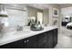 Elegant bathroom with double vanity, black cabinetry, quartz countertop, and framed mirror providing ample space at 1066 Cloud Ridge Ct, Mount Dora, FL 32757