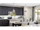 Modern kitchen with stainless steel appliances, dark cabinetry, and an adjacent dining area with stylish pendant lights at 1066 Cloud Ridge Ct, Mount Dora, FL 32757