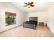 Bright bedroom with a neutral color scheme, features a ceiling fan, a large window, and tile flooring at 1100 Anne Elisa Cir, St Cloud, FL 34772