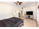 Spacious bedroom showcasing neutral tones, tile flooring, a ceiling fan, and a view into an office area at 1100 Anne Elisa Cir, St Cloud, FL 34772