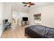 Large bedroom boasting a neutral color palette, ceiling fan, tile flooring, and views into the bathroom at 1100 Anne Elisa Cir, St Cloud, FL 34772