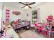 Colorful bedroom with playful decor, featuring a window, a ceiling fan, and laminate wood flooring at 1100 Anne Elisa Cir, St Cloud, FL 34772