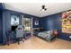Bedroom with a navy blue accent wall, tile floors, a window, and a ceiling fan at 1100 Anne Elisa Cir, St Cloud, FL 34772