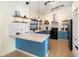 Stylish kitchen featuring blue cabinetry, quartz countertops, and modern fixtures with open shelving at 1100 Anne Elisa Cir, St Cloud, FL 34772