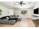 Cozy living room with tile flooring, a sectional sofa, and a large window offering ample natural light at 1100 Anne Elisa Cir, St Cloud, FL 34772