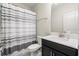 Well-lit bathroom with a shower featuring a gray and white striped curtain and modern vanity at 11120 Whistling Pine Way, Orlando, FL 32832
