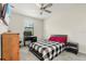 Carpeted bedroom with a black and white bed set, desk, and chair at 11120 Whistling Pine Way, Orlando, FL 32832