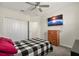 Cozy bedroom features ceiling fan, closet, mounted television, and black and white checkered comforter at 11120 Whistling Pine Way, Orlando, FL 32832