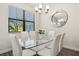 Contemporary dining room featuring a glass table, white chairs, and a modern light fixture at 11120 Whistling Pine Way, Orlando, FL 32832