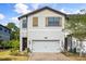 Charming two-story townhome featuring a paver drive, two-car garage and inviting entryway with decorative wreath at 11120 Whistling Pine Way, Orlando, FL 32832