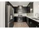 Modern kitchen featuring stainless steel appliances, dark cabinetry, white countertops, and wood-look floors at 11120 Whistling Pine Way, Orlando, FL 32832