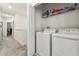 Bright laundry room includes washer, dryer, and storage shelving, conveniently located off the hall at 11120 Whistling Pine Way, Orlando, FL 32832