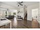 Open concept living room boasts wood-look tile floors, ceiling fan, and flows into kitchen/dining area at 11120 Whistling Pine Way, Orlando, FL 32832