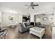 Open-concept living space with wood floors, gray sofa, and adjacent dining and kitchen areas at 11120 Whistling Pine Way, Orlando, FL 32832