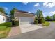Detached garage showcasing manicured landscaping, brick paver driveway and a white door at 1116 Oak Pond Dr, Celebration, FL 34747
