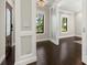 Beautiful hallway with dark hardwood floors, custom millwork and frosted glass door at 1116 Oak Pond Dr, Celebration, FL 34747