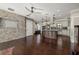 An open-concept living room and kitchen with hardwood floors, granite countertops, stainless appliances, and a stone wall at 1116 Oak Pond Dr, Celebration, FL 34747