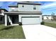 Two-story home with a two-car garage, sliding glass door, and landscaped lawn at 11688 Founders St, Orlando, FL 32832