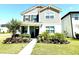 Attractive two-story home with well-kept lawn and colorful flowerbeds lining the walkway at 11688 Founders St, Orlando, FL 32832