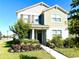 Inviting two-story home features a manicured lawn and colorful flowerbeds, enhancing curb appeal at 11688 Founders St, Orlando, FL 32832