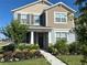 Two-story home boasting colorful flowerbeds and a well-manicured lawn enhances its curb appeal at 11688 Founders St, Orlando, FL 32832