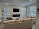 Bright living room with fireplace and mounted TV, and modern window treatments at 11688 Founders St, Orlando, FL 32832
