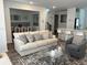 Open-concept living room with a comfortable sofa, gray chair, and view into dining room at 11688 Founders St, Orlando, FL 32832