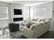 Comfortable living room with a stone fireplace, TV, modern furniture, and large windows at 11688 Founders St, Orlando, FL 32832