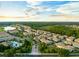 Aerial view of a residential community with lush landscaping, a pond, and a pool at 1231 Sandwedge St, Davenport, FL 33896