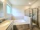 Bright bathroom featuring a soaking tub, a shower with glass door, and a large vanity at 1231 Sandwedge St, Davenport, FL 33896
