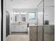 Bathroom featuring double sinks, a window, and a glass-enclosed shower with tiled surround at 1231 Sandwedge St, Davenport, FL 33896