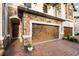 Two-car garage door nestled in a stone facade with brick paver driveway and covered entryway at 1231 Sandwedge St, Davenport, FL 33896