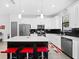 Modern kitchen with white cabinets, a black backsplash, stainless steel appliances, and an island with seating at 1231 Sandwedge St, Davenport, FL 33896