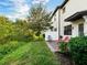 Cozy outdoor patio featuring a privacy fence, red lounge chair, and a peaceful green space at 1231 Sandwedge St, Davenport, FL 33896