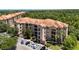 Aerial view of a residential complex with red tile roofs, surrounded by greenery and parking at 1375 Tuscana Ln # 1207, Davenport, FL 33896