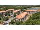 Expansive aerial depicting residential buildings nestled among trees and landscaping at 1375 Tuscana Ln # 1207, Davenport, FL 33896