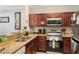 Well-equipped kitchen features stainless steel appliances, wooden cabinets, and granite countertops at 1375 Tuscana Ln # 1207, Davenport, FL 33896