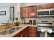 Well-equipped kitchen features stainless steel appliances, wooden cabinets, and granite countertops at 1375 Tuscana Ln # 1207, Davenport, FL 33896
