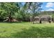 Community playground featuring lush green grass, mature shade trees, a slide and picnic tables under a pergola at 1375 Tuscana Ln # 1207, Davenport, FL 33896