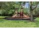 Community playground with a play structure surrounded by grass and bordered with black mulch at 1375 Tuscana Ln # 1207, Davenport, FL 33896