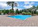 Beautiful community pool with clear blue water, palm trees, lounge chairs, and cabanas for relaxing at 1375 Tuscana Ln # 1207, Davenport, FL 33896