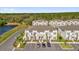 Aerial view of townhomes with manicured landscaping, parking, and lake views at 1385 Peaceful Nature Way, Clermont, FL 34714