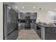 Sleek modern kitchen with stainless steel appliances, dark cabinetry, and ample counter space at 1385 Peaceful Nature Way, Clermont, FL 34714