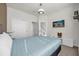 Neutral bedroom with a cozy bed, carpet floors, and a mounted TV for relaxation and entertainment at 1385 Peaceful Nature Way, Clermont, FL 34714