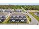 Rear exterior showcasing townhome screened patios with rear yard views and community landscaping near a scenic pond at 1385 Peaceful Nature Way, Clermont, FL 34714