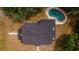 Aerial view of a house with a dark roof and a kidney-shaped pool surrounded by trees and lush greenery at 1400 Florida Ave, St Cloud, FL 34769