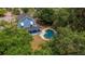 Aerial view of the house, pool, and fenced in yard with lots of trees at 1400 Florida Ave, St Cloud, FL 34769