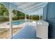 View of back porch overlooking the pool with blue flooring and an outdoor washer and dryer at 1400 Florida Ave, St Cloud, FL 34769